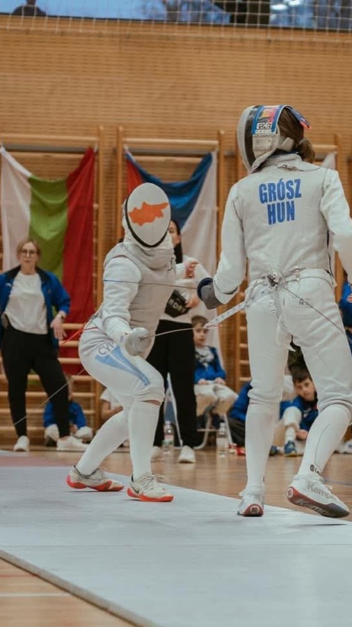 Club fencer in a Cyprus-flag mask during an international bout