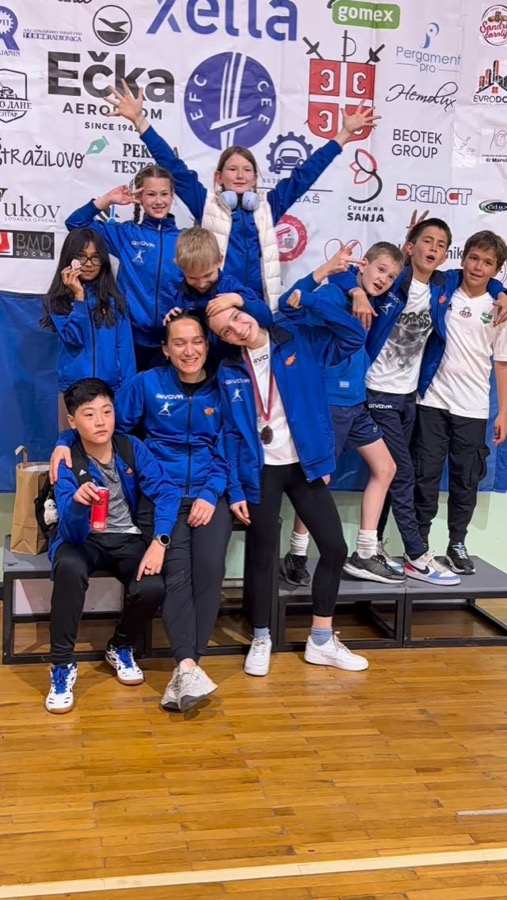Kids team celebrating with their coach after a tournament
