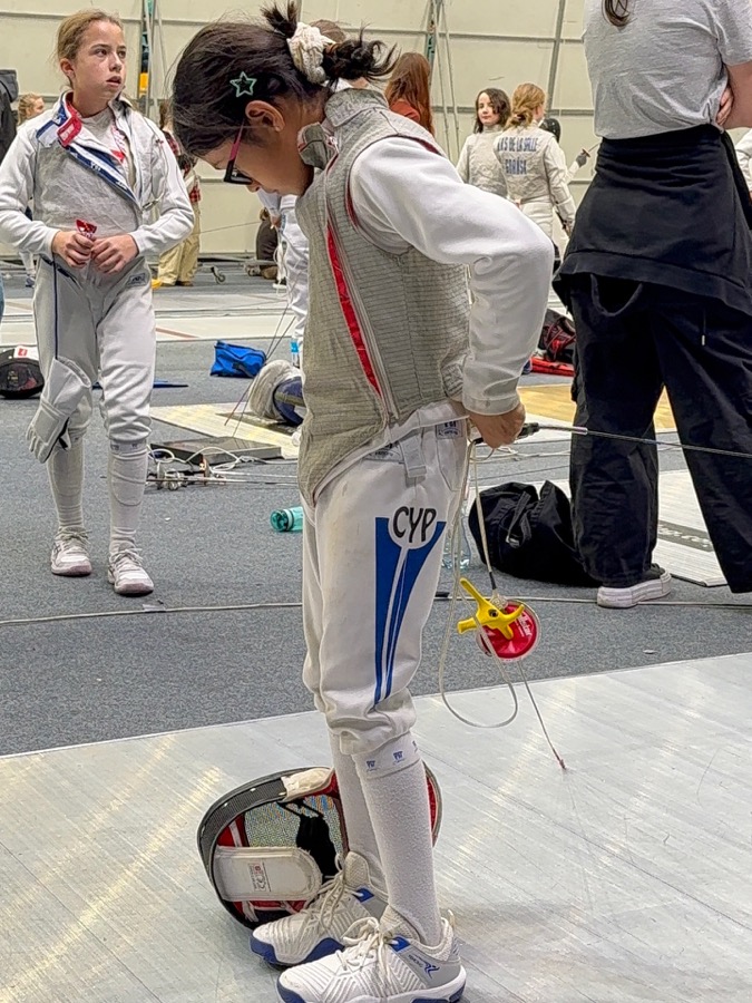 Young fencer putting on equipment before a bout