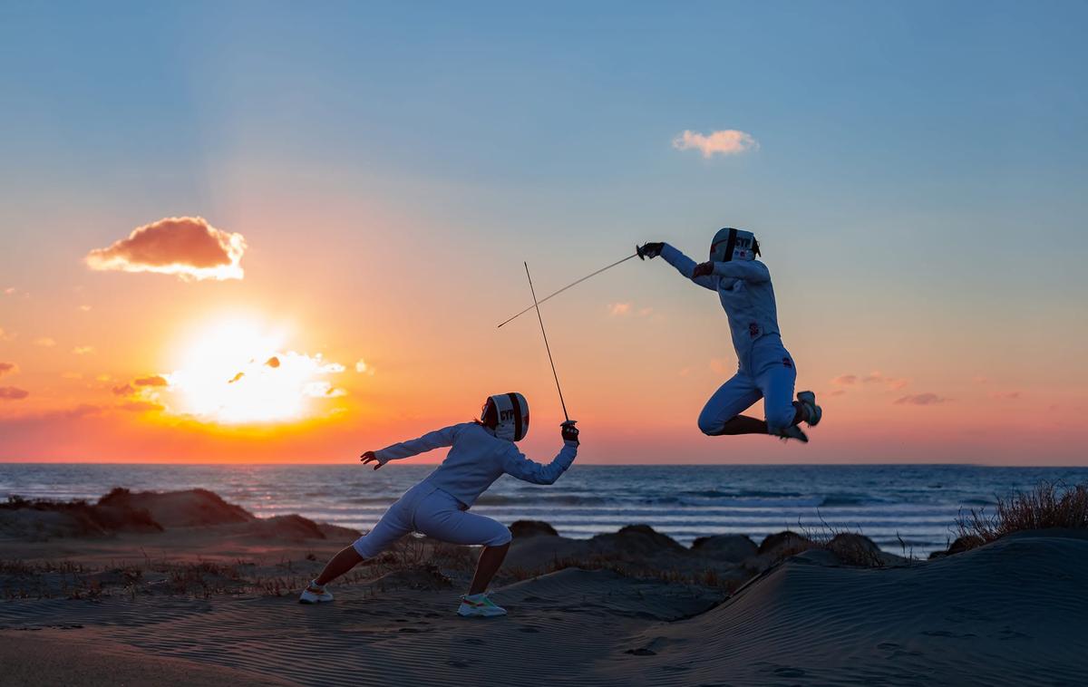 Two club fencers duelling at sunset, one leaping mid-air